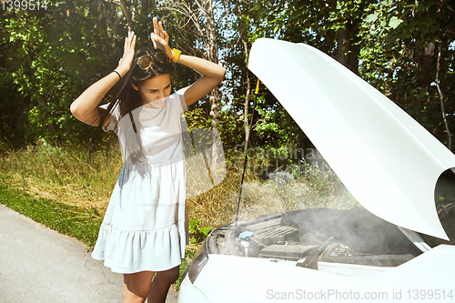 Image of Young woman traveling on the car in sunny day