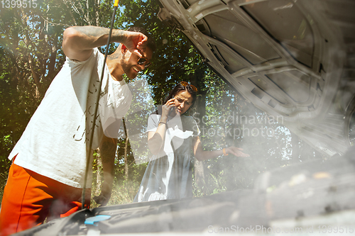 Image of Young couple traveling on the car in sunny day