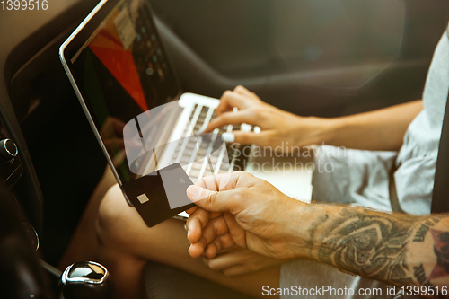 Image of Young couple preparing for vacation trip on the car in sunny day