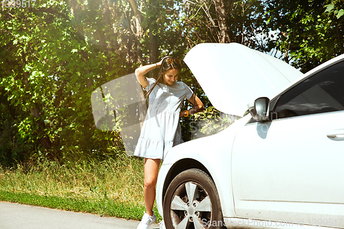 Image of Young woman traveling on the car in sunny day