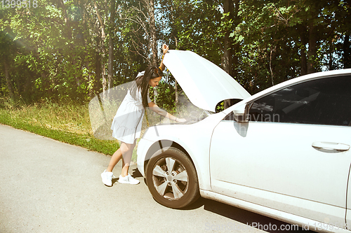 Image of Young woman traveling on the car in sunny day