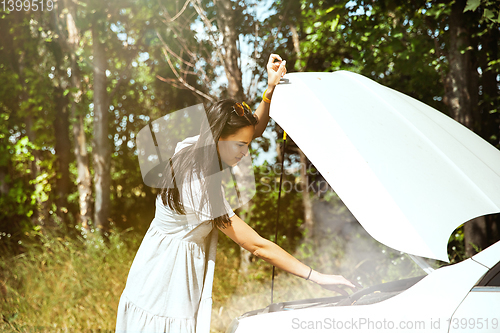 Image of Young woman traveling on the car in sunny day