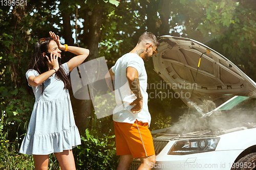 Image of Young couple traveling on the car in sunny day