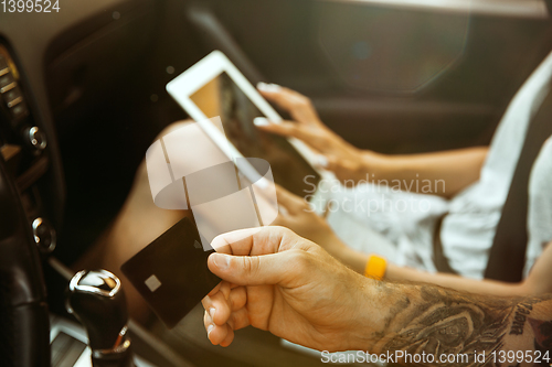 Image of Young couple preparing for vacation trip on the car in sunny day