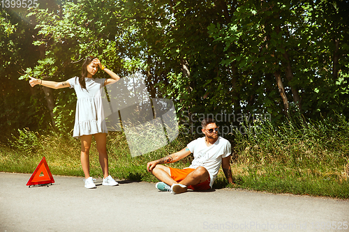 Image of Young couple traveling on the car in sunny day