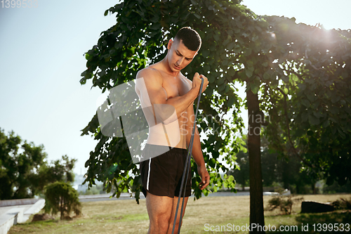 Image of A male athlete doing workout on the city\'s street or park