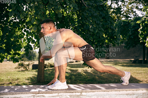 Image of A male athlete doing workout on the city\'s street or park