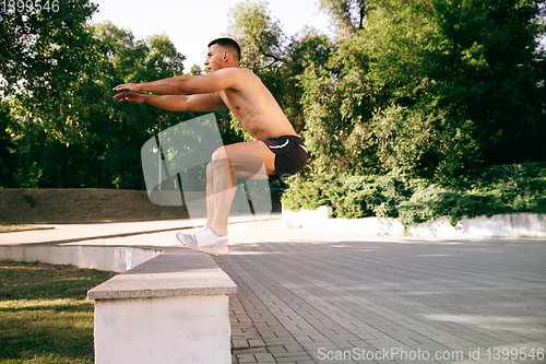 Image of A male athlete doing workout on the city\'s street or park