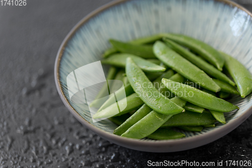 Image of peas in bowl on wet slate stone background