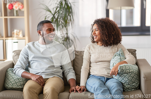 Image of happy african american couple on sofa at home