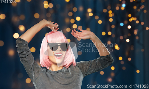 Image of happy woman in pink wig and sunglasses dancing