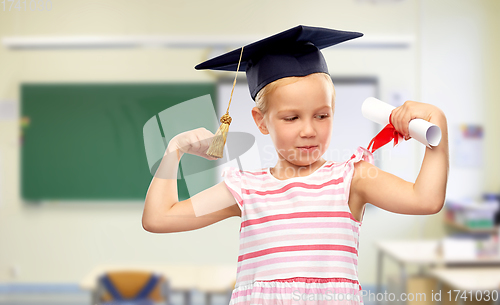 Image of little girl in mortarboard with diploma at school