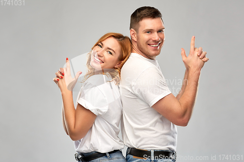 Image of couple in white t-shirts shirts making gun gesture