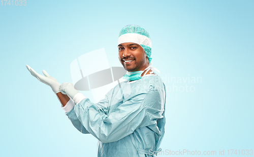 Image of indian male doctor or surgeon putting glove on