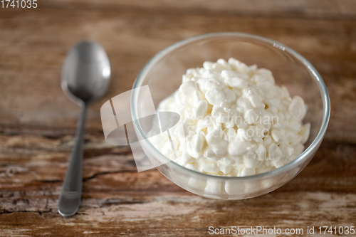 Image of close up of cottage cheese in bowl on wooden table