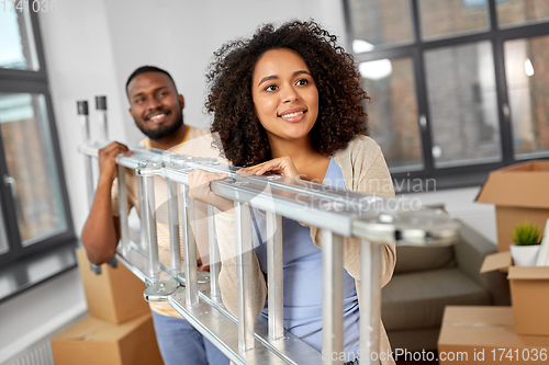 Image of happy couple with ladder moving to new home