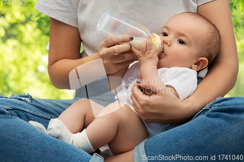 Image of close up of mother feeding baby with milk formula