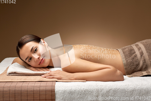 Image of woman lying with sea salt on skin at spa