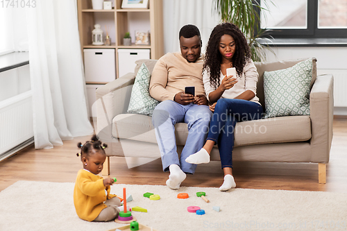 Image of african baby girl playing with toy blocks at home