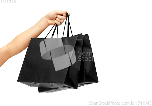 Image of female hand holding black shopping bags