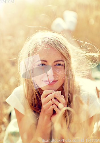 Image of happy woman or teen girl lying in cereal field