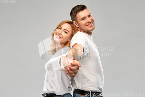 Image of happy couple in white t-shirts holding hands