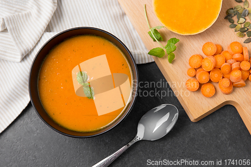 Image of vegetable pumpkin cream soup in bowl with spoon