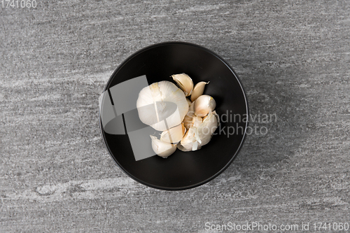 Image of garlic in bowl on slate stone background