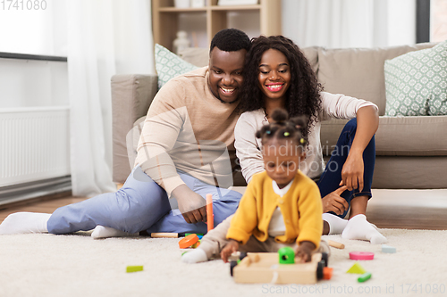 Image of african family playing with baby daughter at home