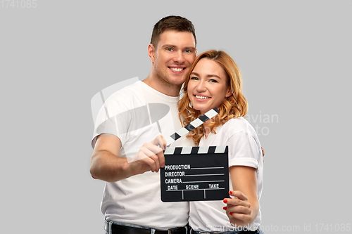 Image of happy couple in white t-shirts with clapperboard