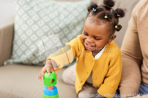 Image of african family playing with baby daughter at home