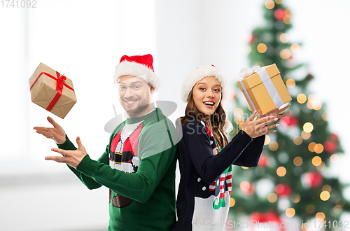 Image of happy couple in christmas sweaters with gifts