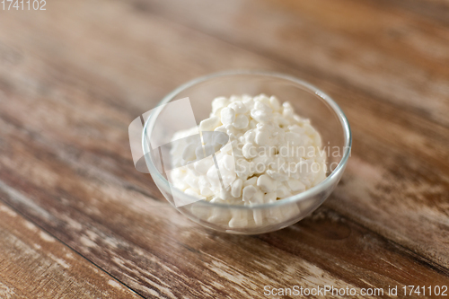 Image of close up of cottage cheese in bowl on wooden table