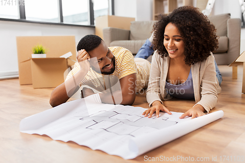 Image of couple with boxes and blueprint moving to new home