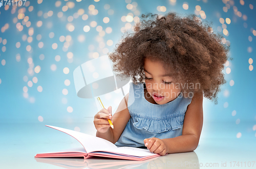 Image of happy little african american girl with sketchbook