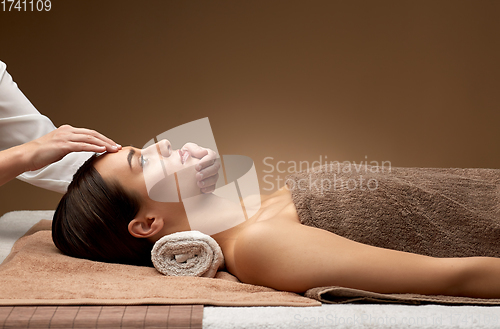 Image of woman having face and head massage at spa