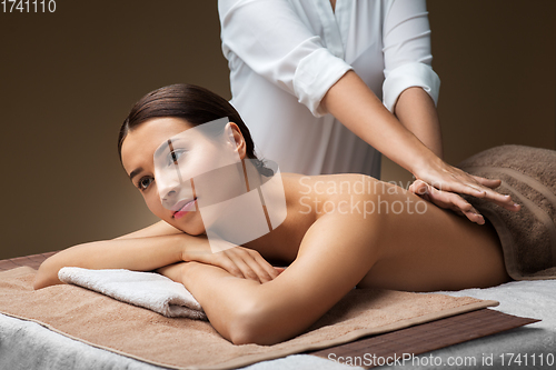 Image of woman lying and having back massage at spa