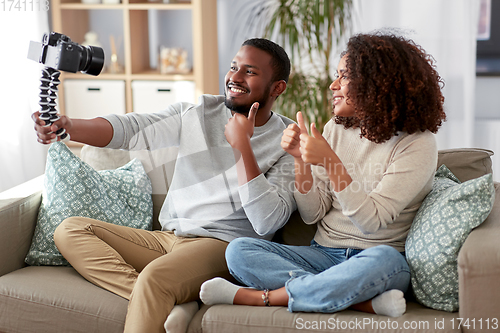 Image of couple of video bloggers with camera at home