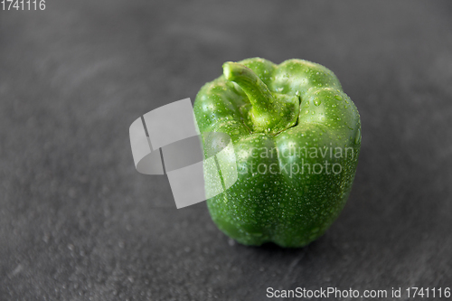 Image of close up of green pepper on slate stone background