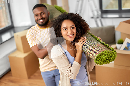 Image of happy couple with carpet moving to new home