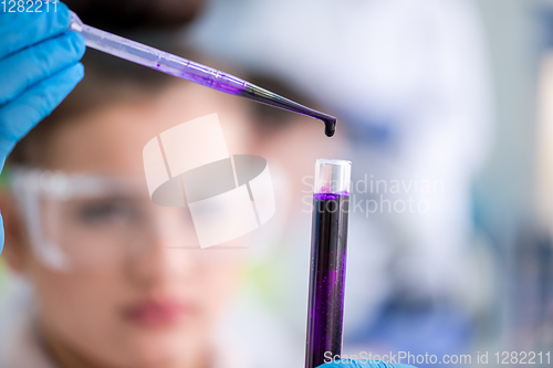 Image of female student with protective glasses making chemistry experime