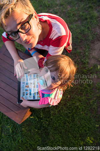 Image of mom and her little daughter using tablet computer