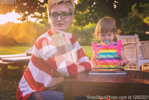 Image of mom and her little daughter using tablet computer