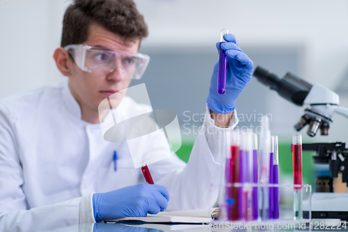 Image of student with protective glasses making chemistry experiment