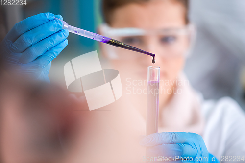 Image of female student with protective glasses making chemistry experime