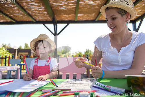 Image of mom and little daughter drawing a colorful pictures