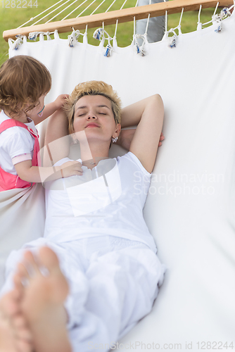 Image of mother and a little daughter relaxing in a hammock