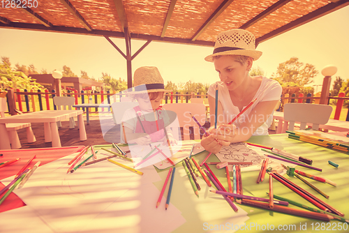 Image of mom and little daughter drawing a colorful pictures