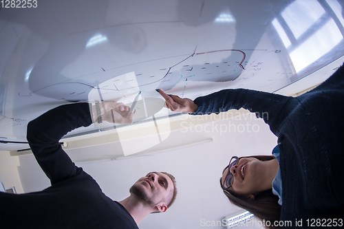 Image of students writing on the white chalkboard