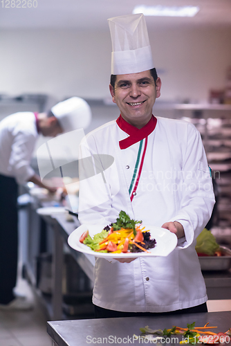 Image of Chef showing a plate of tasty meal